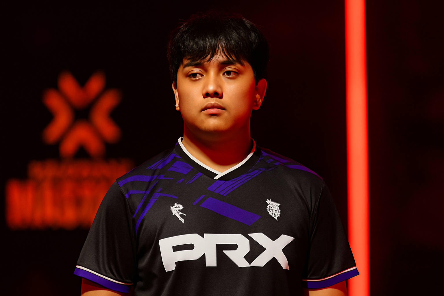 Jugador de PRX en primer plano con expresión seria, iluminado por luces rojas durante el VALORANT Masters Toronto.