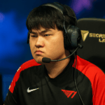 Jugador profesional de T1 concentrado durante una partida de League of Legends en un escenario de esports, con ambiente competitivo e iluminación intensa.