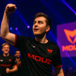 torzsi celebrando con el puño en alto en el escenario del Budapest Major con el logo de MOUZ de fondo y sus compañeros detrás