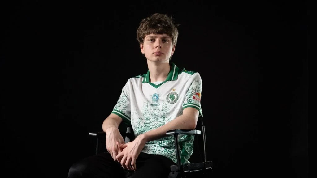 Team Falcons CS2 player kyousuke sitting on a chair while looking fiercely at the camera on a black background.